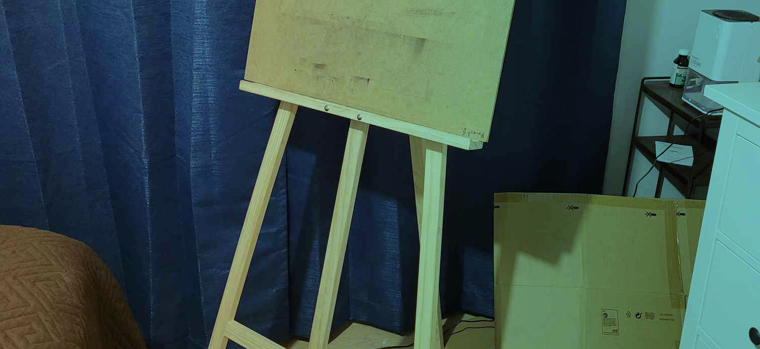 cropped image with an easel and cardboard box